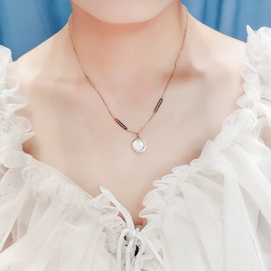 Elegant rose gold Roman numeral necklace with round white shell pendant worn by a model