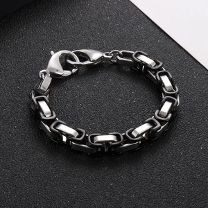 Close-up of dual-tone black and silver Byzantine chain bracelet with lobster clasp
