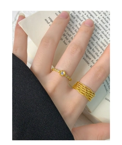 Close-up of stacked S925 silver rings with moonstone and woven lace gold design
