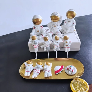 Dettaglio del set decorativo di astronauti in resina con figurine e ganci a muro