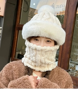 Detail of plush cream knitted hat with faux fur pompom and thick warm neck warmer