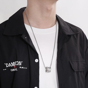 Detailed view of multilayer silver hip-hop necklace with round pendants on a model