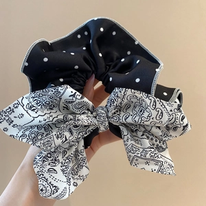 Gros plan détaillé d'un chouchou à pois avec motifs paisley et tissu doux et fluide