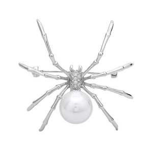 Silver spider brooch with large white pearl and sparkling crystals on white background