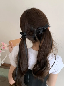 Détail de nœuds à cheveux noirs avec rose pour coiffure tressée style ballet