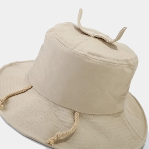 Minimalist beige canvas bucket hat with decorative sprouts and braided windproof rope