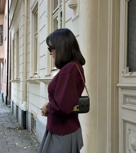 Detailaufnahme des goldenen Vintage-Verschlusses und Musters der braunen Ledertasche