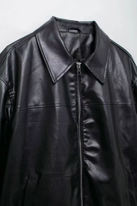 Detail of classic black faux leather aviator jacket featuring metallic zipper and collar