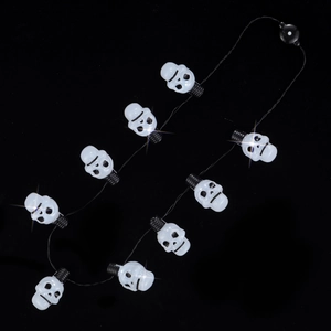 Macro shot of Halloween string lights featuring white skull bulbs with starlight glow