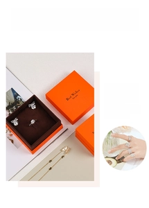 Macro shot of orange textured jewelry boxes with gold Best Wishes foil and velvet lining