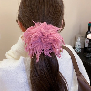 Vue détaillée d'un chouchou en plumes rose vif porté en queue de cheval de dos