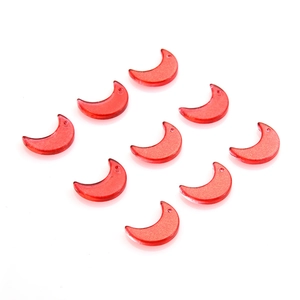 Close-up of nine red moon-shaped acrylic pendants for DIY jewelry and crafts