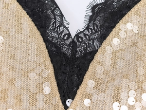 Close-up of black lace and gold sequins on an elegant cocktail dress for women