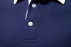 Close-up of navy blue polo sweatshirt featuring a white knit collar and shell texture buttons
