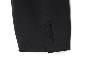 Detailed macro view of black blazer cuffs with four matching fabric-covered buttons