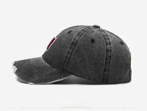 Side view of vintage distressed denim baseball cap in dark gray with raw edge detailing