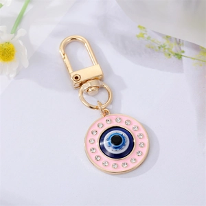 Porte-clés œil protecteur coloré avec émail rose et cristaux sur fond de fleurs minimalistes