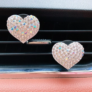 Detail of two sparkling rhinestone heart-shaped car air vent aromatherapy clips