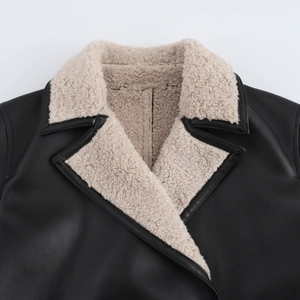 Dettaglio di un cappotto in pelle nera con risvolto e colletto in finta pelle di pecora beige