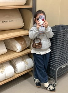 Vue détaillée du mini sac enfant léopard avec bandoulière en chaîne et logo métal