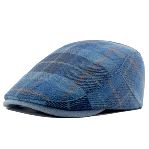 Close-up of classic blue plaid wool blend beret hat with tweed texture and stiff brim