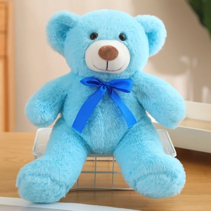 Cute light blue plush teddy bear sitting on a stand with a dark blue bow tie