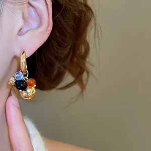 Vintage gold hoop earrings with colorful stone bead pendants shown on model