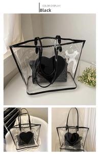 Detail of transparent PVC tote bag with black heart-shaped inner pouch and patent leather handles