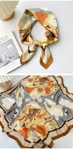 Close-up of vintage floral silk scarf with elegant orange and blue patterns in satin finish