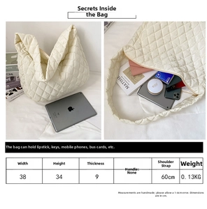 Detail showing high-capacity interior of quilted bag with phone, keys, and cosmetics