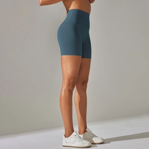 Detail view of high-waist teal blue yoga shorts showing the matte fabric and slim fit