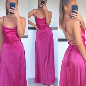 Détail d'une robe longue en satin rose avec col bénitier et dos nu à lacets croisés