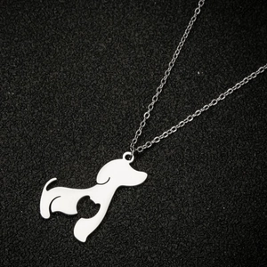 Detailed view of silver dog silhouette pendant with hollow cat design on black surface