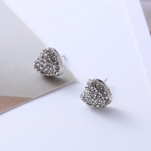 Macro detail of silver heart earrings featuring pave-set white round crystals