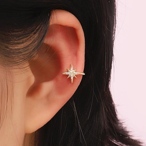 Detailed view of an eight-pointed star ear cuff with gold plating and sparkling stones