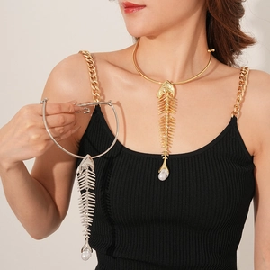 Detail of gold and silver fishbone pendant necklaces with pearl charms on model