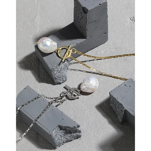 Baroque freshwater pearl necklace with silver and gold toggle clasp chains on stone blocks