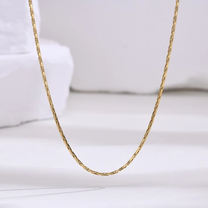 Close-up of sleek 1mm golden stainless steel snake chain showing smooth metallic luster