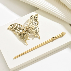 Detailed view of a golden butterfly hairpin set on a minimalist white geometric stand