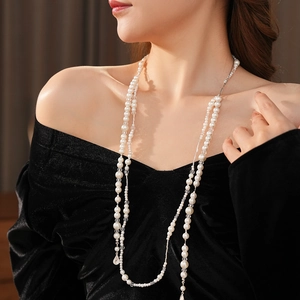 Détail du collier de perles multicouches vintage français sur une tenue élégante