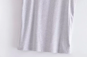 Dettaglio ravvicinato del tessuto in maglia grigio chiaro e dell'orlo della t-shirt