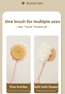 Close-up of dual-sided bath brush with soft yellow bristles and white mesh sponge loofah