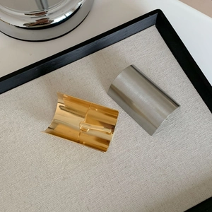 Polished gold and brushed silver high ponytail clips on a linen display tray