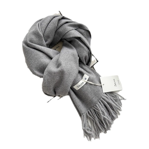 Gray cashmere-feel scarf with elegant tassels on a minimalist white background