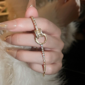 Gros plan d'un bracelet doré avec des accents géométriques en zircon et sertissage pavé
