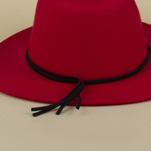 Detail eines roten Wollfilzhutes mit schwarzem Flechtband und Quasten am Rand
