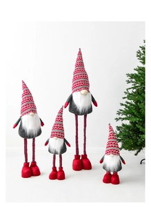 Close-up of four Christmas gnomes with striped legs and knit hats in white setting