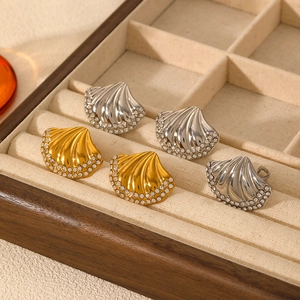 Elegant shell-shaped rings with zircon crystals on a velvet jewelry display tray