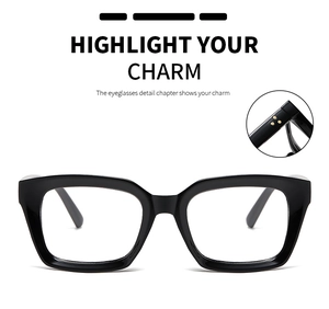 Detail view of black thick square glasses frame with golden rivets on the hinge