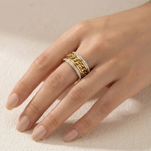 Gros plan d'une bague chaîne gourmette dorée avec pavé de diamants sur le doigt d'un mannequin